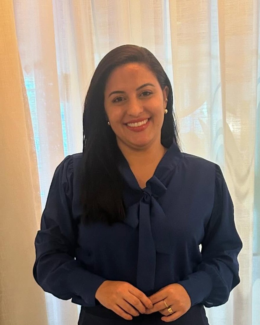 A advogada Patrícia Alencar, de blusa azul-marinho com laço, sorrindo